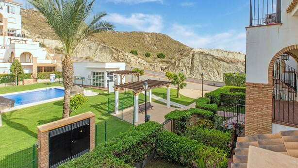 Zona residencial con piscina, una pérgola y vistas a un paisaje montañoso.