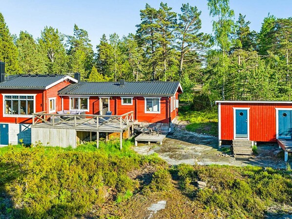 Relax on the spacious deck surrounded by lush greenery and trees.