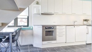 A modern kitchen with white cabinets, a built-in oven, and a coffee machine. - 5 Person Holiday Park Home in Gudhjem (Gudhjem)