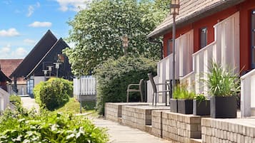 Una calle residencial con casas, un sendero y plantas en macetas.