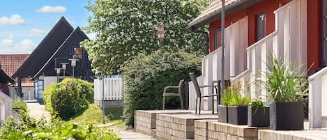 A residential street with houses, a pathway, and potted plants.