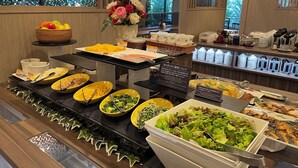 Een buffetopstelling met diverse gerechten en een bloemdecoratie.