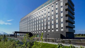 Een modern Route Inn hotelgebouw met een opvallend bord, meerdere verdiepingen en een parkeerplaats ervoor.