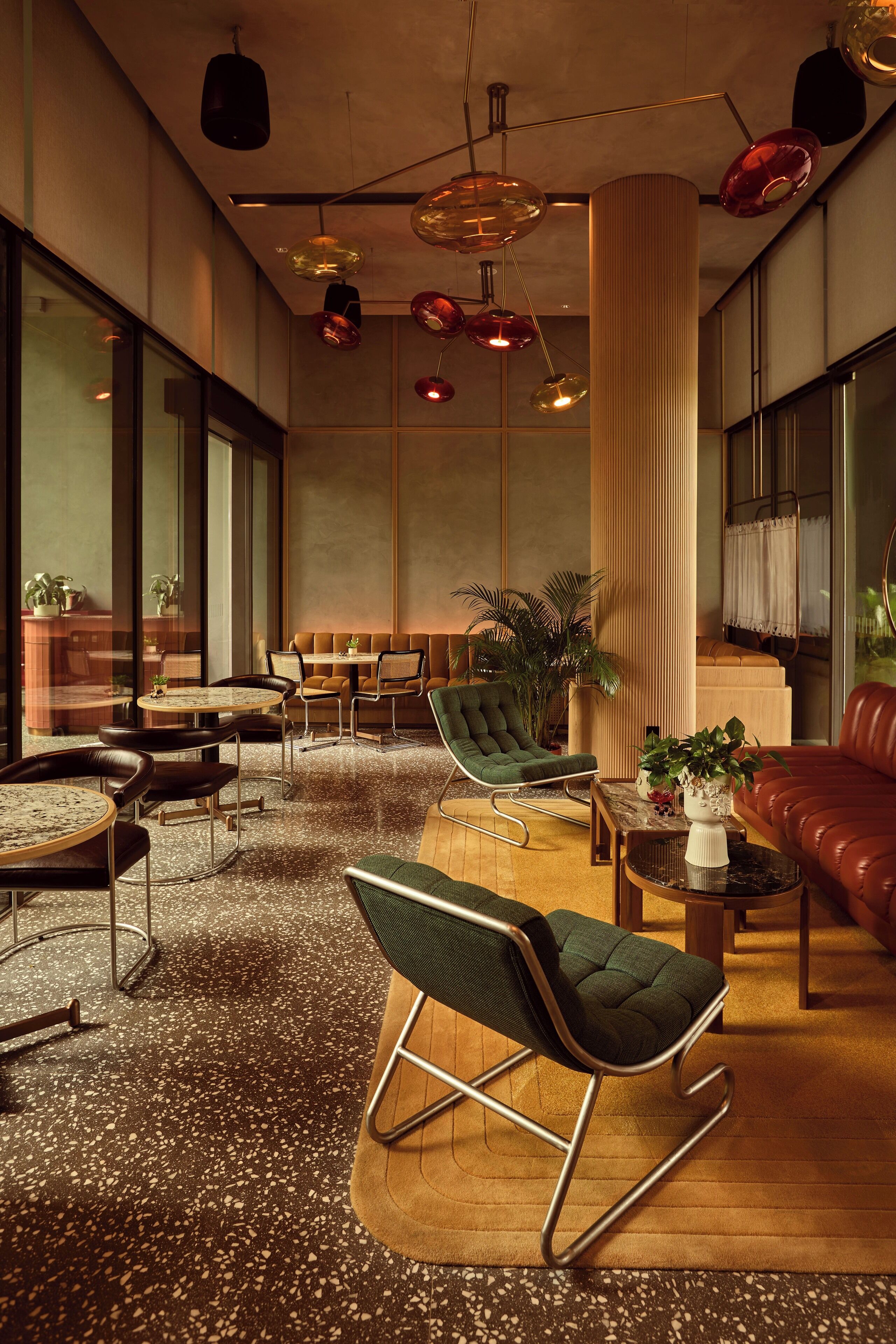 Un espace de détente moderne, doté de sièges, de tables et d’un éclairage décoratif.