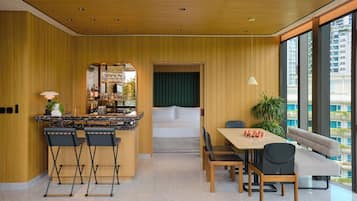 Una cocina moderna con paneles de madera, una barra y un comedor con sofá y sillas.