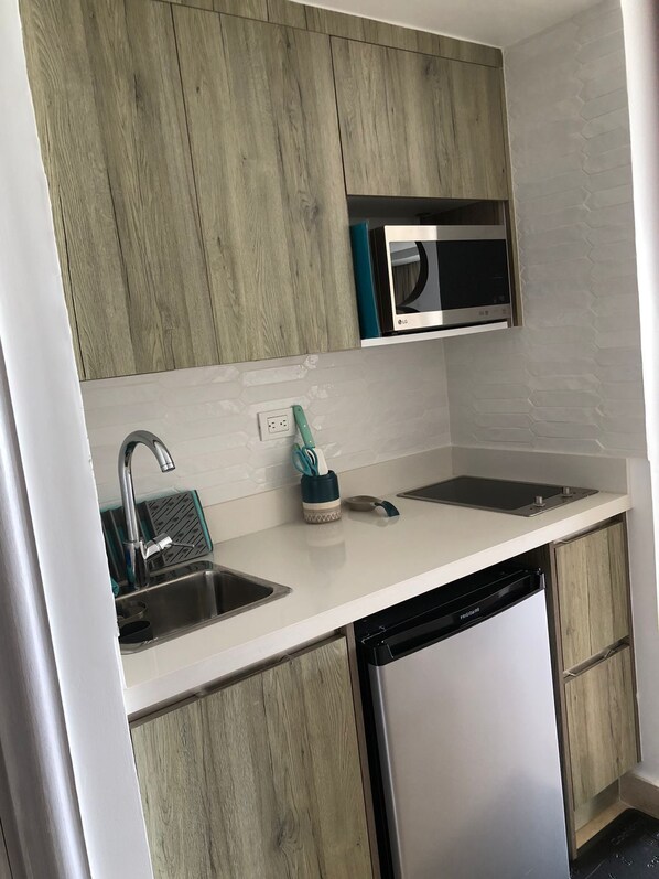 A modern kitchen with wooden cabinets, a stainless steel sink, a microwave, and a dishwasher.