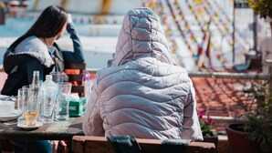 A person sitting at a table with a view of a large, colorful structure in the background. - Boudha Stupa View Guest House (Kathmandu)