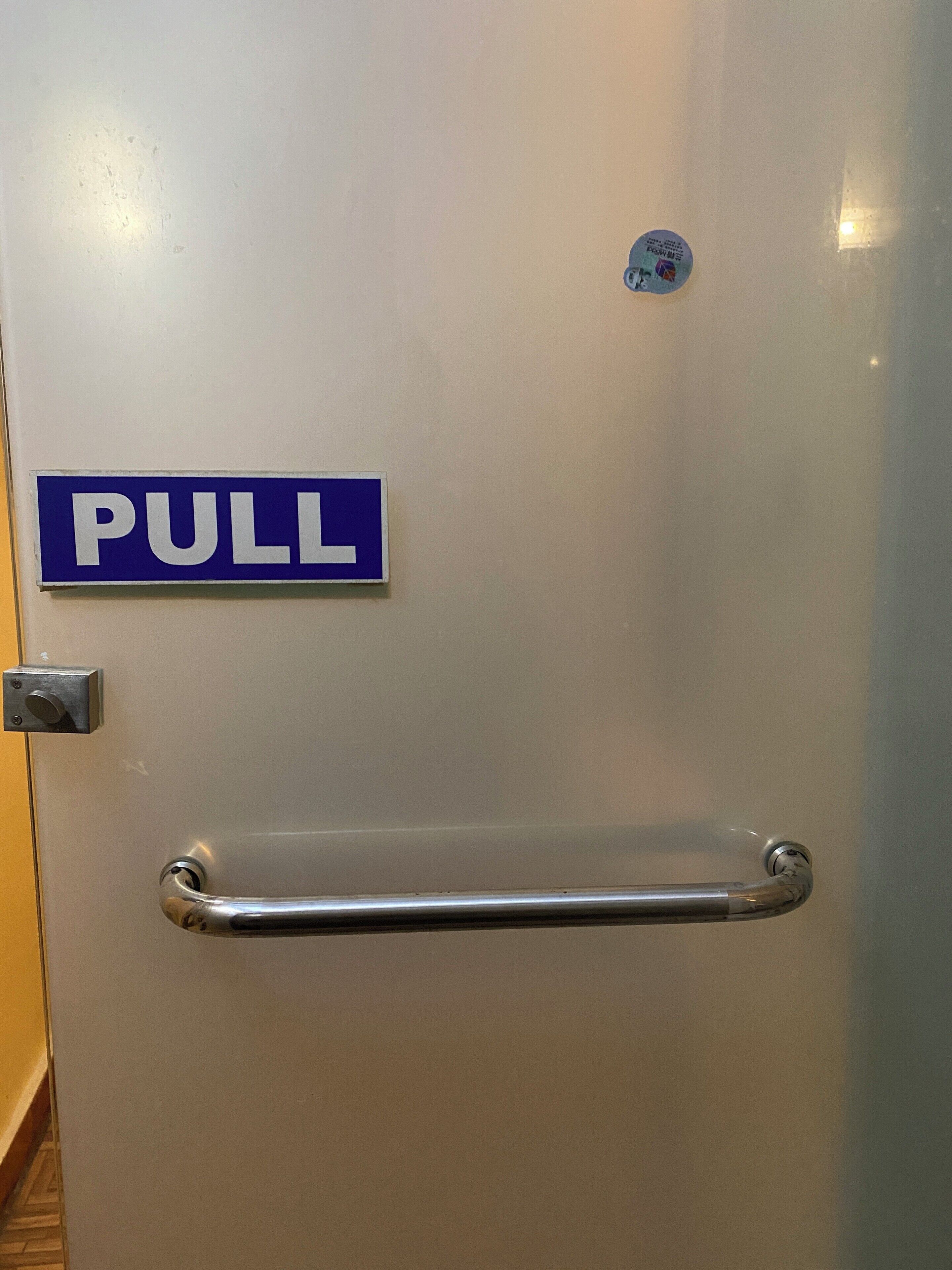 A door with a 'PULL' sign and a metal handle.