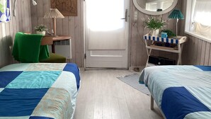 A room with two beds, a desk, a chair, a mirror, and a door. - 4 Star Holiday Home in Hvide Sande (Hvide Sande)