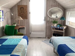 A room with two beds, a desk, a chair, a mirror, and a door. - 4 Star Holiday Home in Hvide Sande (Hvide Sande)