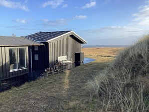 A coastal building with a bench and potted plants outside. - 4 Star Holiday Home in Hvide Sande (Hvide Sande)