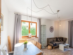 A modern living room with a dining table, sofa, and a glass cabinet. - Apartment in Westendorf (Westendorf)