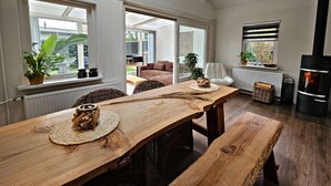 Un vaste espace de vie comprenant une table à manger en bois, un canapé et une cheminée.