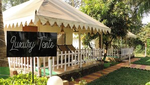 Una tenda de luxe amb un cartell que diu "Luxury Tents" en un jardí.