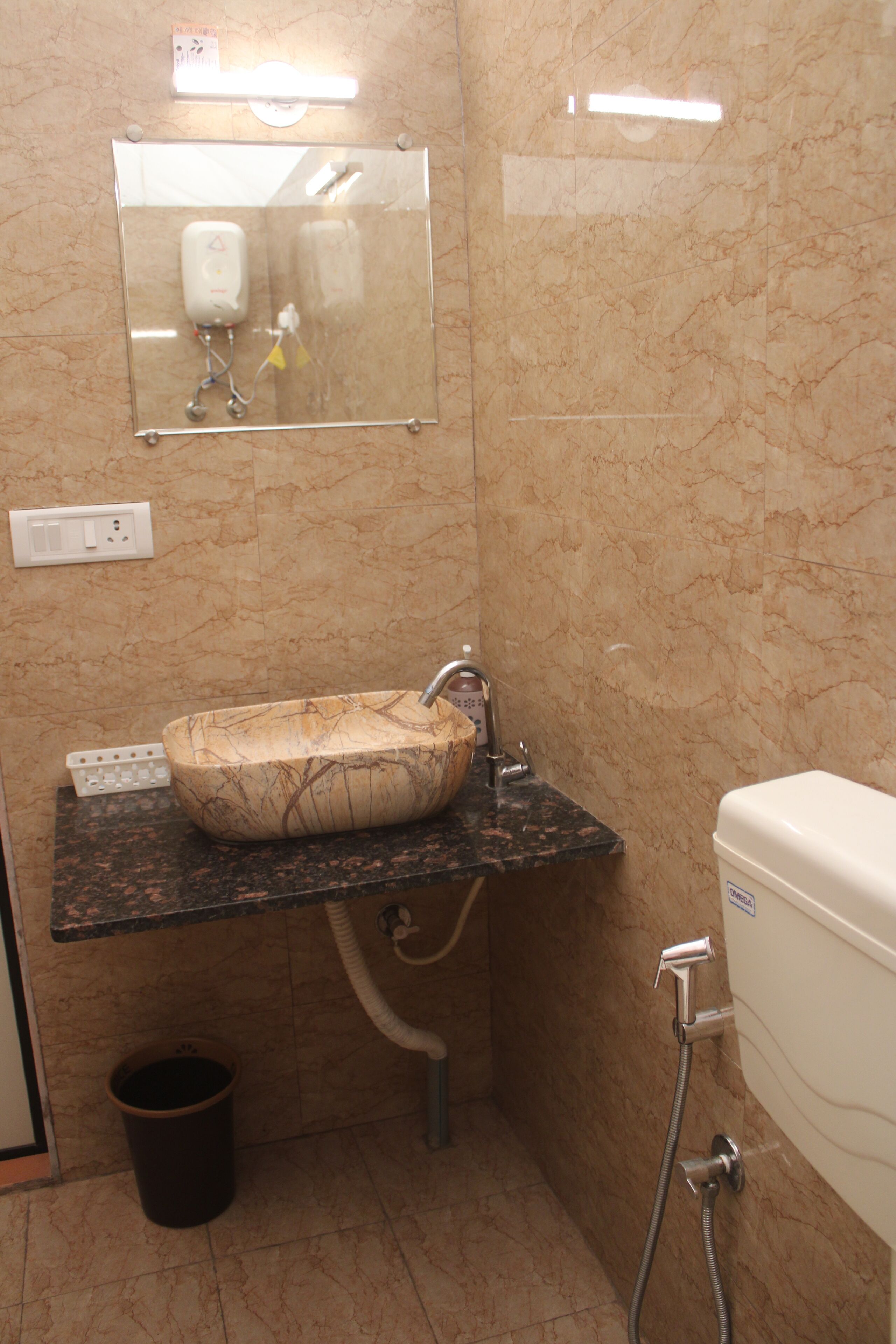 A bathroom with a marble sink, a mirror, a toilet, and a shower.