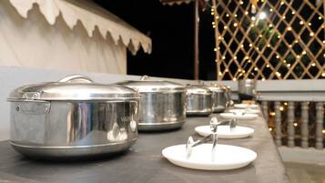 Ollas de acero inoxidable sobre una mesa, presumiblemente para un servicio de buffet o catering.