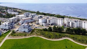 A coastal residential area with modern apartment buildings, a marina, and a clear view of the sea. - Holiday Apartment Sanddorn WE 7 (Boergerende-Rethwisch)