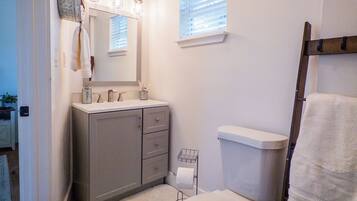 Une petite salle de bain comprenant des toilettes, un lavabo et un miroir.