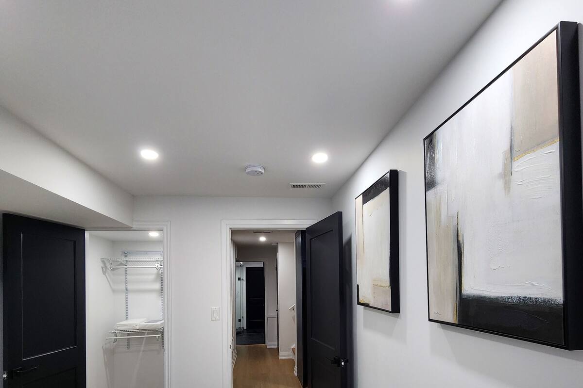 A hotel room with a bed, a walk-in closet, and a hallway with doors leading to other rooms.