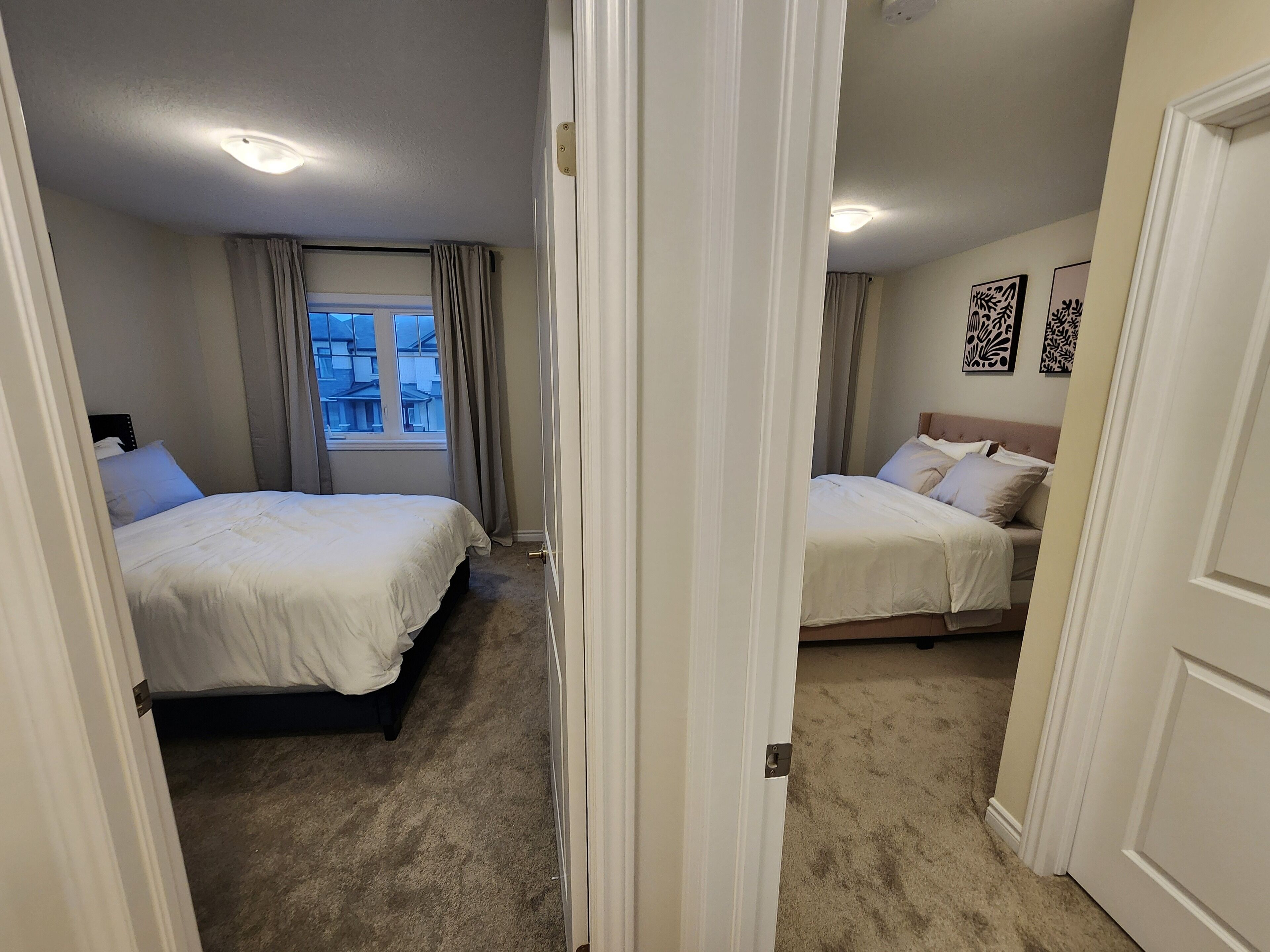 Een hotelkamer met twee bedden, een raam met gordijnen, een vloerbedekking en een plafondlamp.