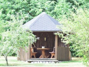A wooden gazebo with a hexagonal roof, a central table, and two chairs. - Schroder at the Aerie (Kargow)