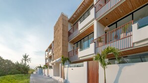 Un hotel moderno con múltiples balcones, ventanas amplias y fachada de madera.