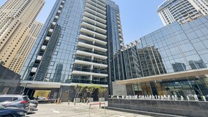 Een modern hoog gebouw met reflecterende glazen ramen en een reeks balkons.