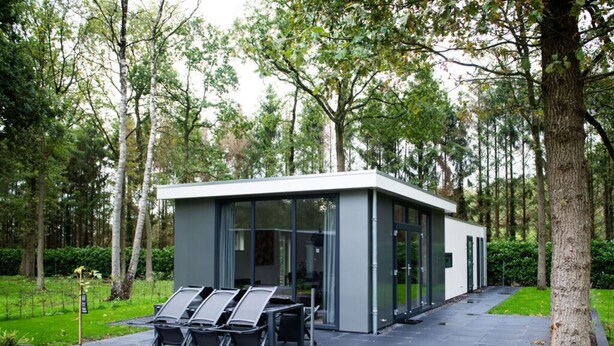 A modern, glass-walled building with a minimalist design, surrounded by a lush green park. - Charming Apartment in Graach an der Mosel (Zorgvlied)