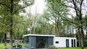 A modern, single-story building with a flat roof, large glass windows, and a small porch area. - Charming Apartment in Graach an der Mosel (Zorgvlied)