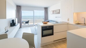 Une cuisine moderne avec vue sur la plage, un coin repas et un espace de vie.