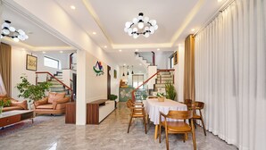Un amplio salón con una mesa de comedor, sofás de cuero y una escalera que sube a un piso superior.