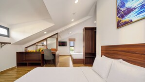 Un dormitorio con una cama grande, un escritorio con silla, un televisor y un cabecero de madera.