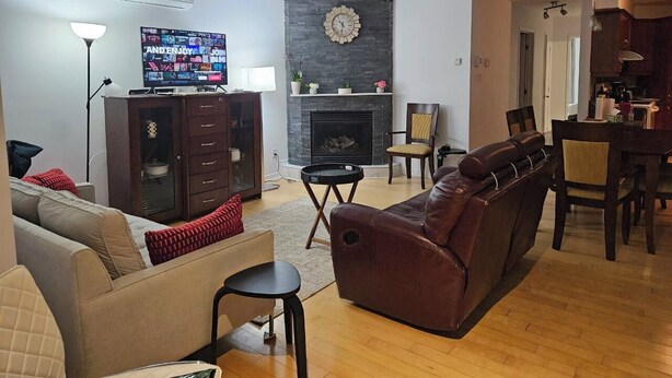 A living room with a fireplace, a television, and a dining area.