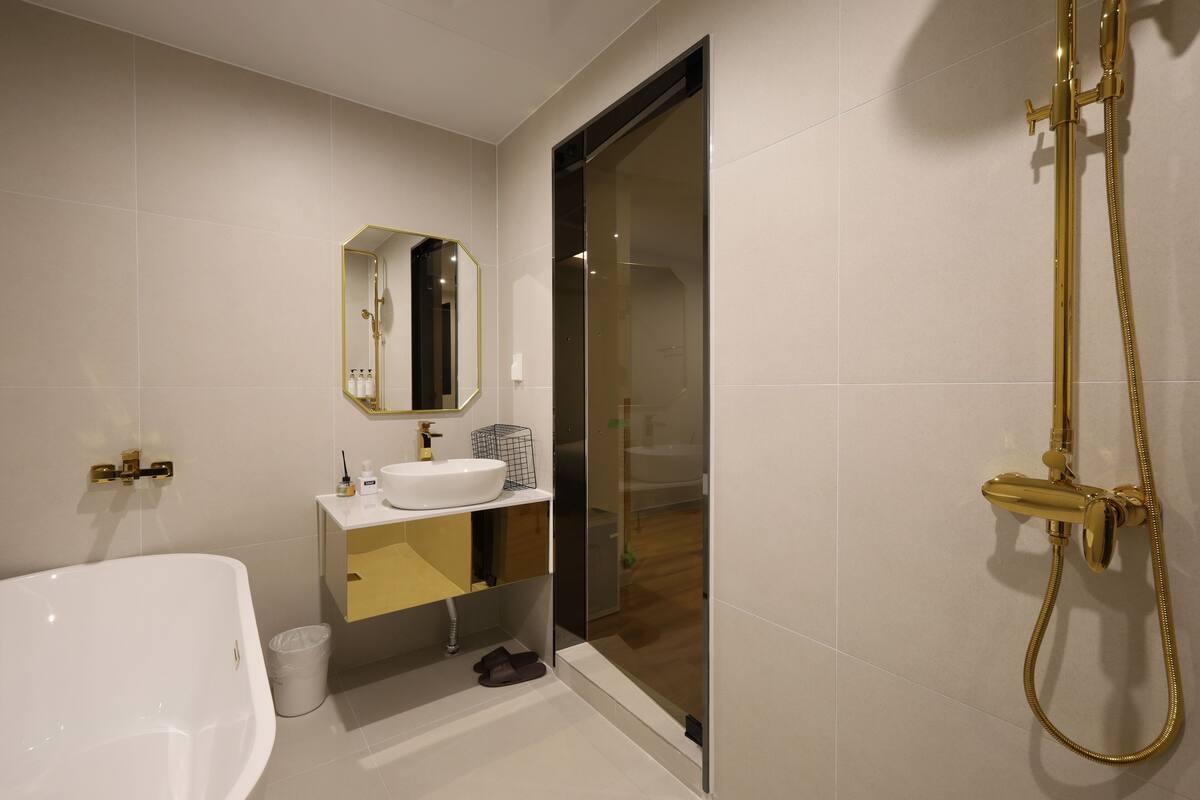 Une salle de bain moderne avec une baignoire, un lavabo, un miroir et une douche.