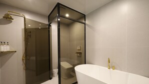Un bagno moderno con una vasca freestanding, una cabina doccia in vetro e un water.