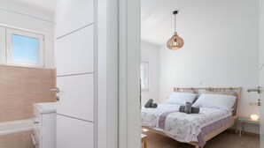 A bedroom with a wooden bed, a bedside table, and a hanging light fixture. - Sun4Fun by Interhome (Trogir/Okrug Gornji)