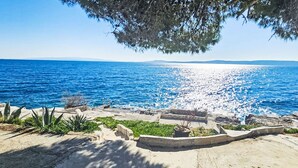 A coastal view with a clear sky, a rocky shoreline, and a calm sea. - Sun4Fun by Interhome (Trogir/Okrug Gornji)