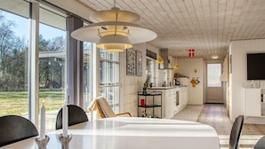 Una cocina moderna con armarios blancos, una isla central e iluminación colgante.