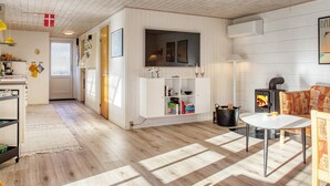 Una cocina moderna con armarios blancos, estufa integrada y un comedor con mesa y sillas.