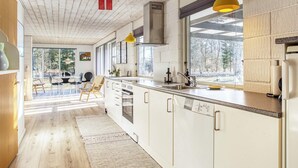 Una cocina moderna con vigas de madera, un ventanal y vistas al exterior.