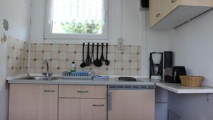 A kitchen with a window, a sink, cabinets, and a coffee maker. - Bungalow Oberspreewald 3 (Schwielochsee)