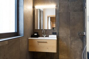A modern bathroom with a wooden vanity, a mirror, and a window. - Apartment in Schrocken Near Ski Arlberg (Schroecken)