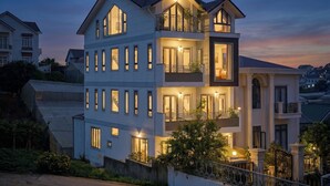 Un edificio residencial de varios pisos con balcones, ventanas amplias y un acceso con portón.