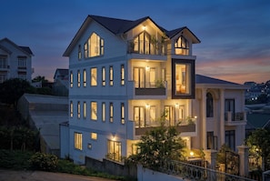 Un edificio residencial de varios pisos con balcones, ventanas amplias y un acceso con portón.