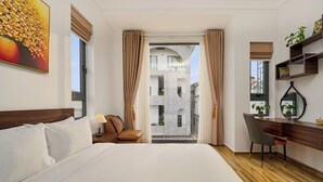 Una habitación de hotel con cama, escritorio, silla y vistas al exterior.