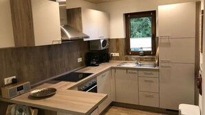 A modern kitchen with a central island, built-in microwave, and stainless steel appliances. - Holiday Home Goldstuck (Oberharz am Brocken)