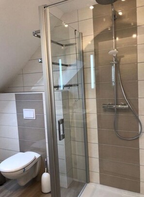 A modern bathroom with a glass-enclosed shower, a toilet, and a bidet. - Holiday Home Goldstuck (Oberharz am Brocken)