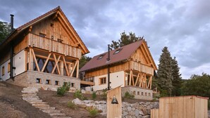 Puinen vuoristomökki, jonka kivestä rakennetut portaat johtavat puiseen terassiin.