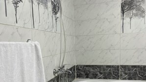 A bathroom with a bathtub, a shower, and a towel rack. - Farido Pyramids (Giza)
