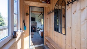 Un intérieur en bois avec une cheminée, un banc et un luminaire suspendu.